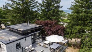 Een modern huis met een dakterras, buitenmeubilair en uitzicht op de oceaan.
