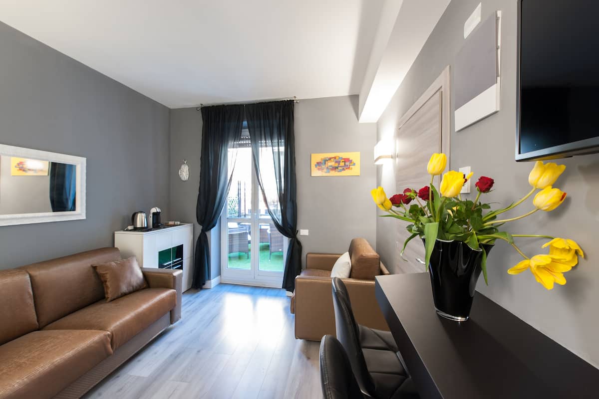 Ein modernes Wohnzimmer mit einer Couch, einem Esstisch und einer Blumenvase.