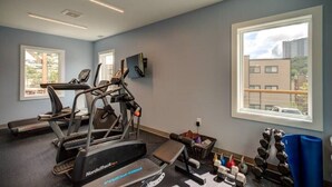 A gym with treadmills, dumbbells, and a blue mat. - Suite Spot at Sugar-Mountain Views (Sugar Mountain)