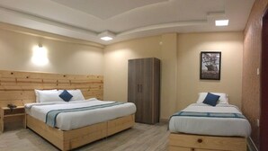 A hotel room with two wooden beds, a wardrobe, and a framed picture on the wall. - Snow Crest Lodges (Mekhtar)