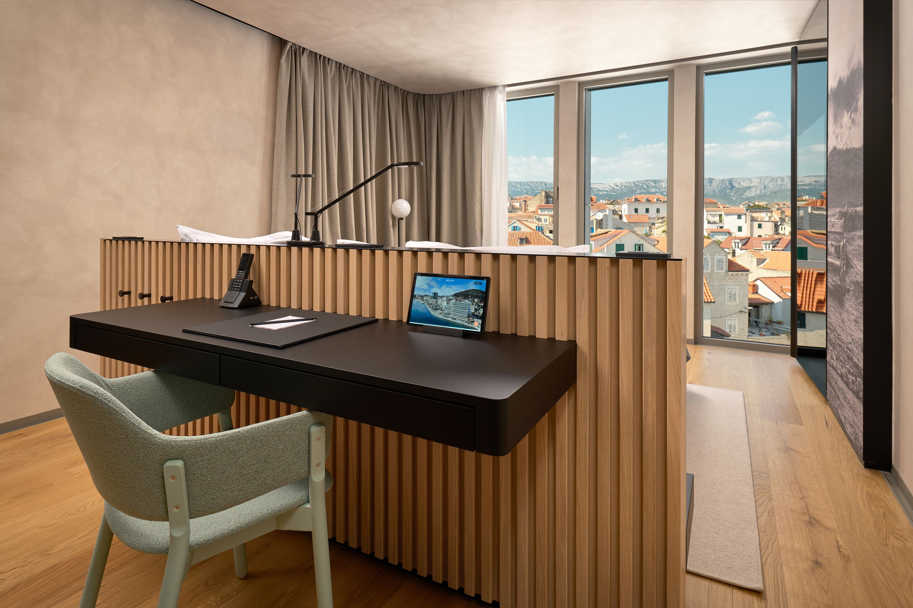 Un espacio de oficina moderno con escritorio, silla y ventanas amplias que ofrecen vistas a la ciudad.