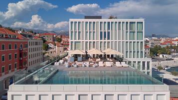 Una piscina al aire libre de temporada, sombrillas