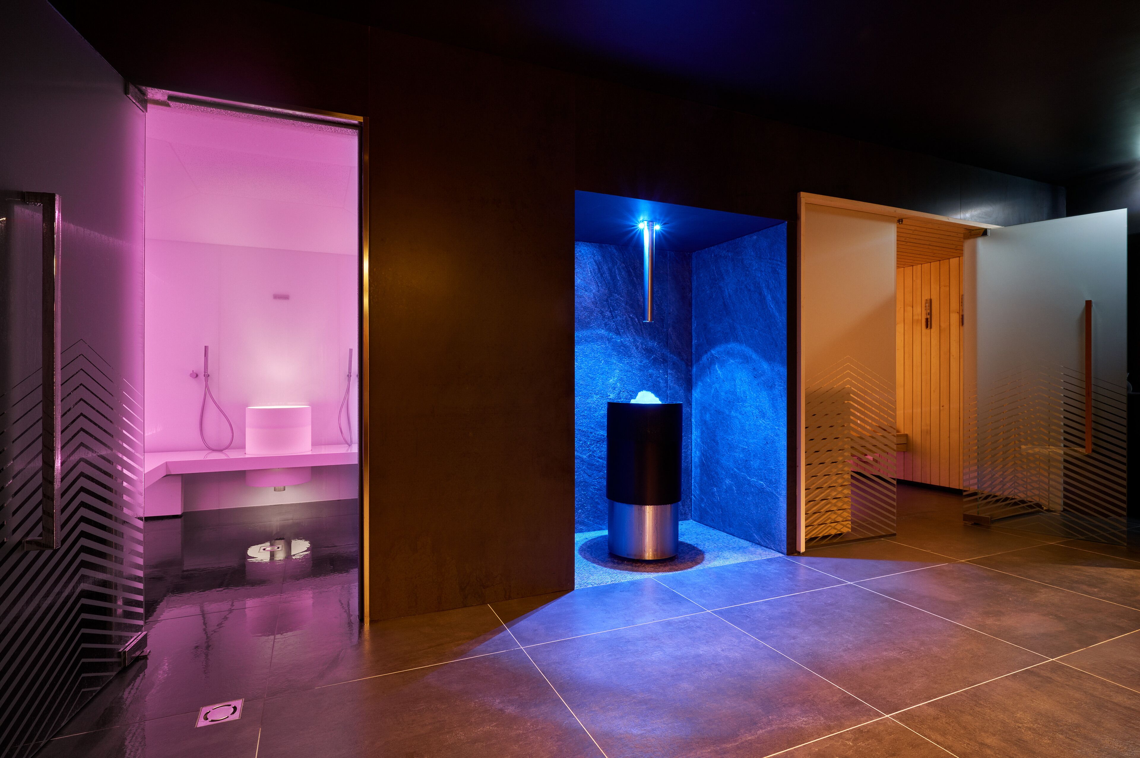 A modern spa area with a sauna, a massage chair, and a relaxation area.
