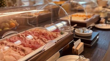 Un bufé con diversos tipos de carne y un plato con un llavero.