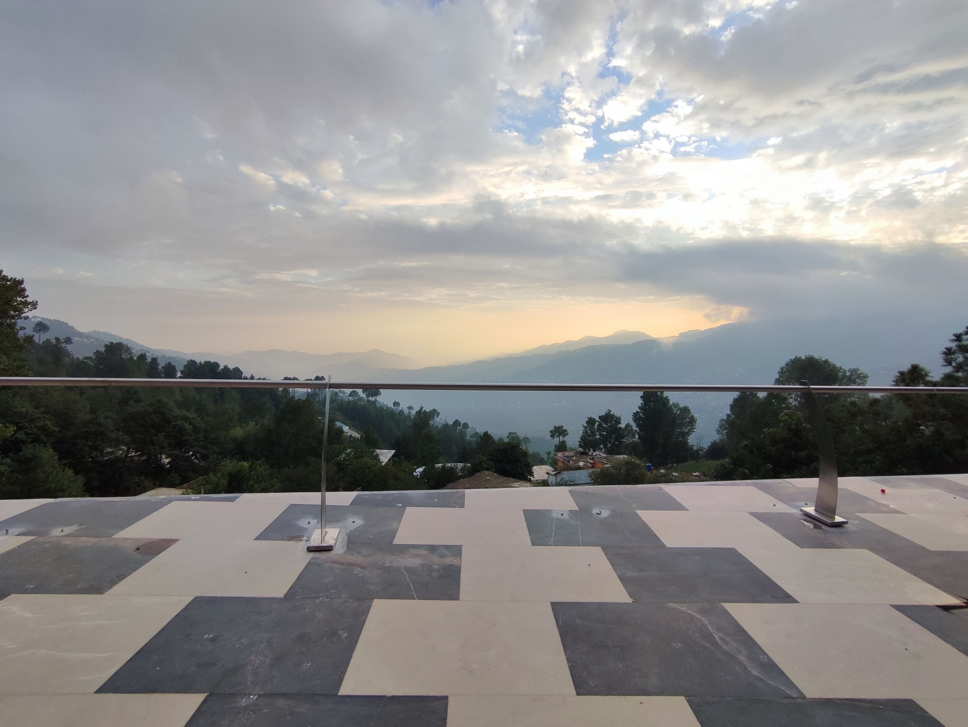 Una terraza con vista a montañas distantes y un cielo nublado.