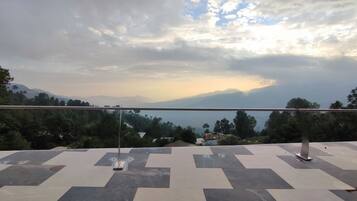 Una terraza con vista a montañas distantes y un cielo nublado.