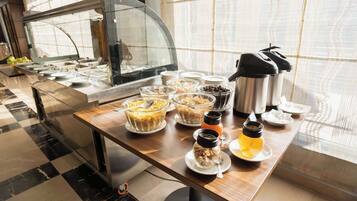 Una mesa de buffet con diferentes recipientes de comida y una estación de café.