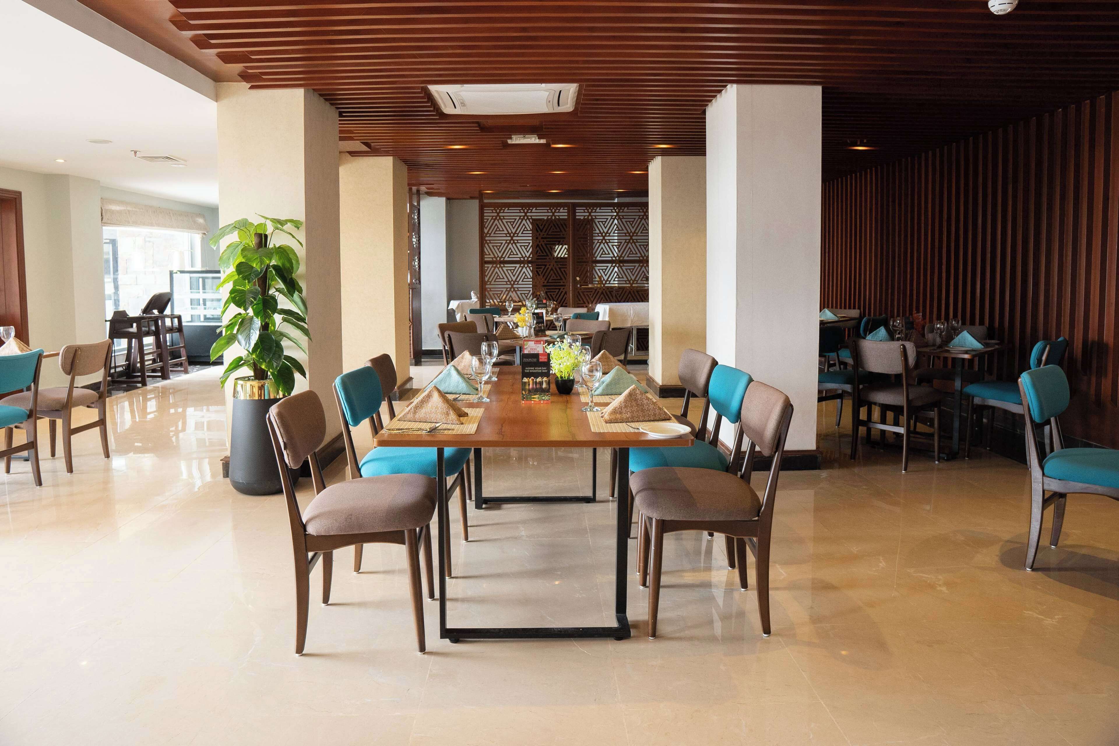 Un amplio comedor con una larga mesa dispuesta para una comida, rodeada de sillas.