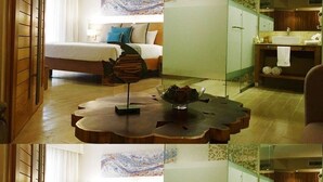 A hotel room with a bed, a wooden coffee table, and a bathroom with a sink and mirror. - Luxurious 1 Bedroom Tropical Junior Suite (Dominican Republic)