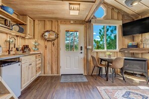 Un intérieur en bois comprenant un coin cuisine, une table à manger et une cheminée.