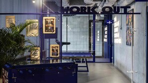A modern workspace with a 'WORK OUT' area, including a foosball table and a bench. - Adagio Access Gent Centrum Dampoort (Ghent)