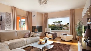 A modern living room with a fireplace, a sofa, a coffee table, and a view of the outdoors. - Large outdoor with privacy, Heated pool 60m2 , Gamesroom ,Wellness, Garden (Karojba)
