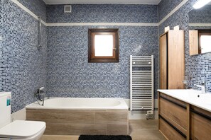 A bathroom with a bathtub, a toilet, and a sink.
