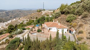 Une villa située sur une colline, dotée d’une piscine, entourée d’arbres et offrant une vue sur la vallée.