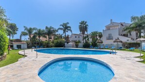 A swimming pool with a stone deck, surrounded by palm trees and lounge chairs. - Studio Apartment '19A Claire' with Pool, Private Garden & Wi-Fi (El Paraiso)