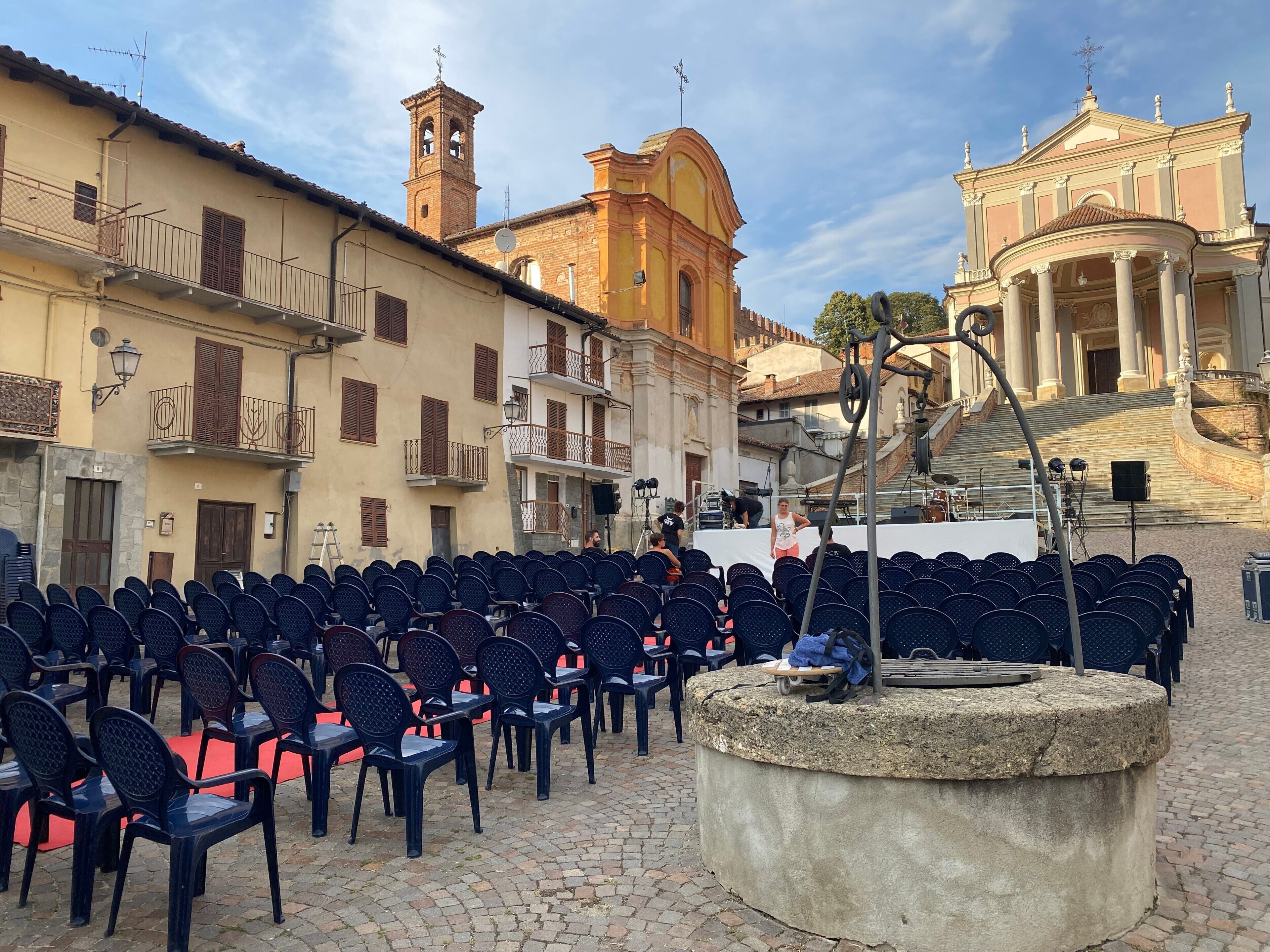 An outdoor seating area with rows of chairs and a stone fountain.