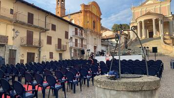 An outdoor seating area with rows of chairs and a stone fountain.