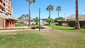 Cortile di un hotel con palme, una piscina e un edificio con balconi.