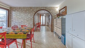 Un espace repas agrémenté d’un mur en briques, d’une arche en bois et d’un meuble avec des tiroirs.