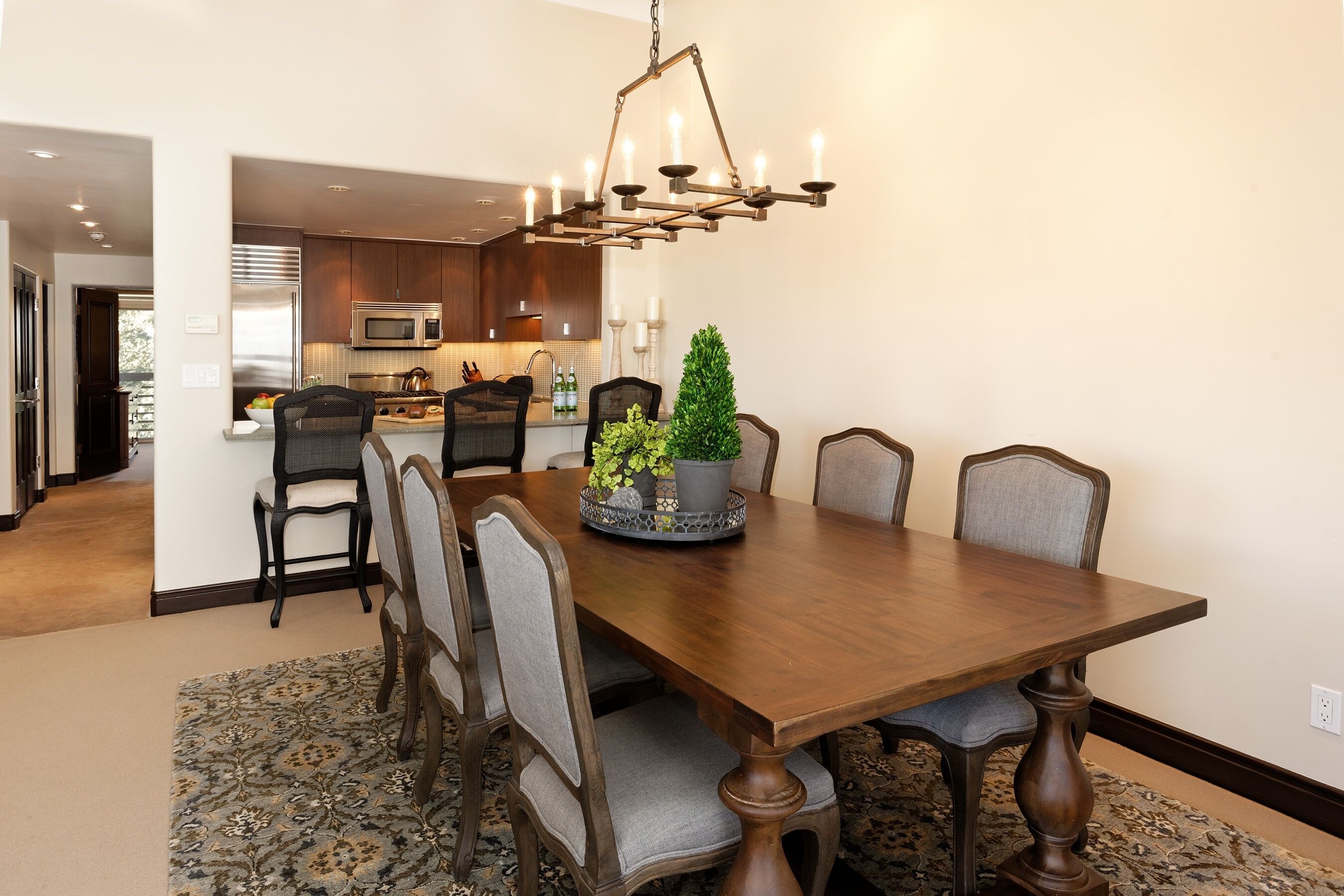 Comedor con mesa de madera, seis sillas y una araña.