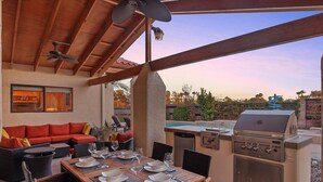 An outdoor patio with a dining table set for six, a grill, and a pool in the background. - Luxury one level villa on 1/2 acre 12 min from The Strip (Las Vegas)