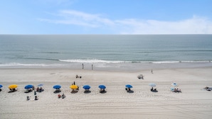 A beach with several umbrellas and people. - 0511 Waters Edge Resort 2 Bedroom Condo by RedAwning (Murrells Inlet)