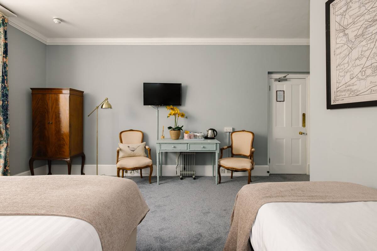 Ett hotellrum med två sängar, ett skrivbord, en TV och en garderob.