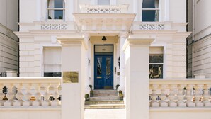 Un bâtiment blanc avec une porte bleue et le chiffre « 20 » au-dessus.