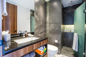 Et moderne badeværelse med en stor vask, spejl og toilet.