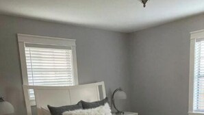 Ein modernes Schlafzimmer mit einem Bett, Nachttischen und einem Beistelltisch.