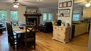 A spacious living area with a fireplace, wooden dining table, and comfortable seating. - NEW!Lakefront retreat with huge dock, private cove. Perfect for Clemson Football (Central)