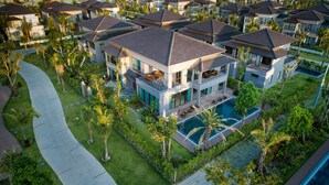 A modern resort with multiple two-story buildings, a central swimming pool, and well-maintained tropical landscaping. - Best Western Premier Sonasea Villas Phu Quoc (Phu Quoc)