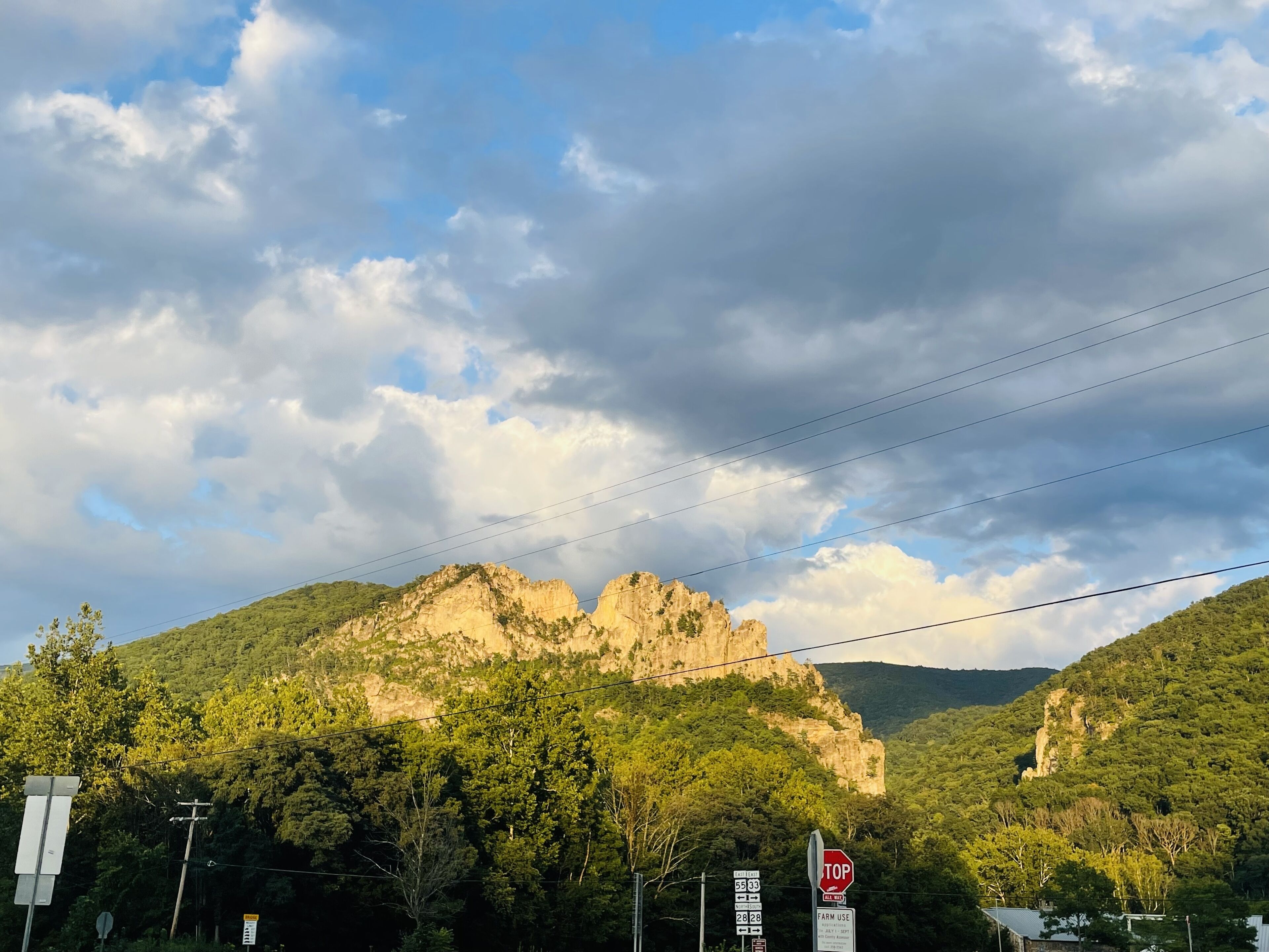 Un paysage montagneux avec un panneau de signalisation et des panneaux routiers au premier plan.