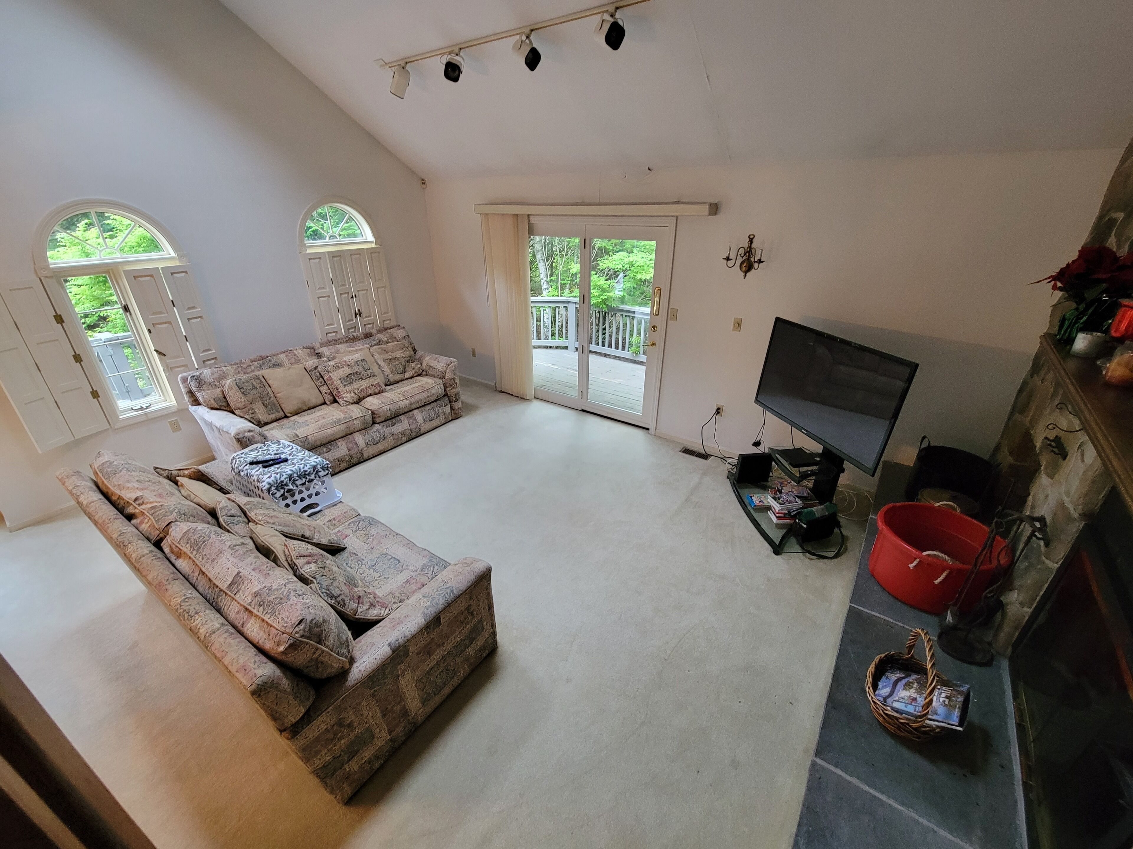A spacious living room with a large sectional sofa, a flat-screen TV, and a fireplace.