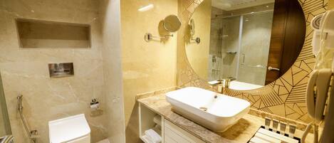 A modern bathroom with a large mirror, a sink, and a shower.