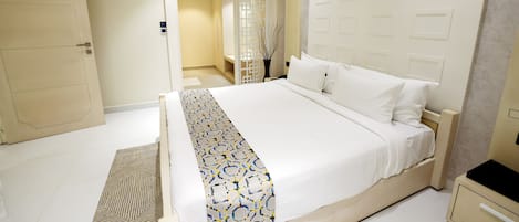 Una habitación de hotel moderna con una cama grande, una mesita de noche y un armario.