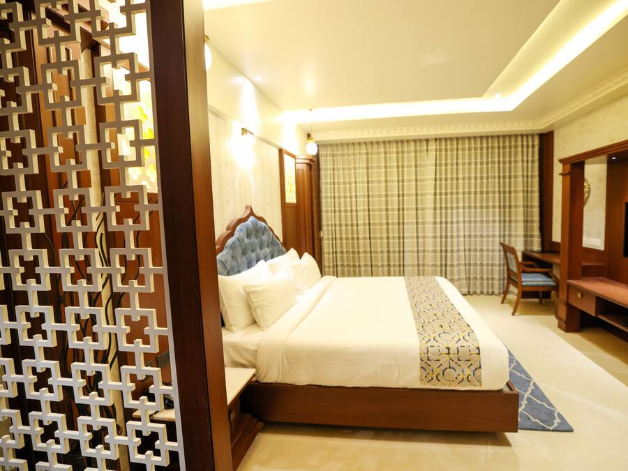 Une chambre d’hôtel avec un lit, un bureau, une chaise et un téléviseur.