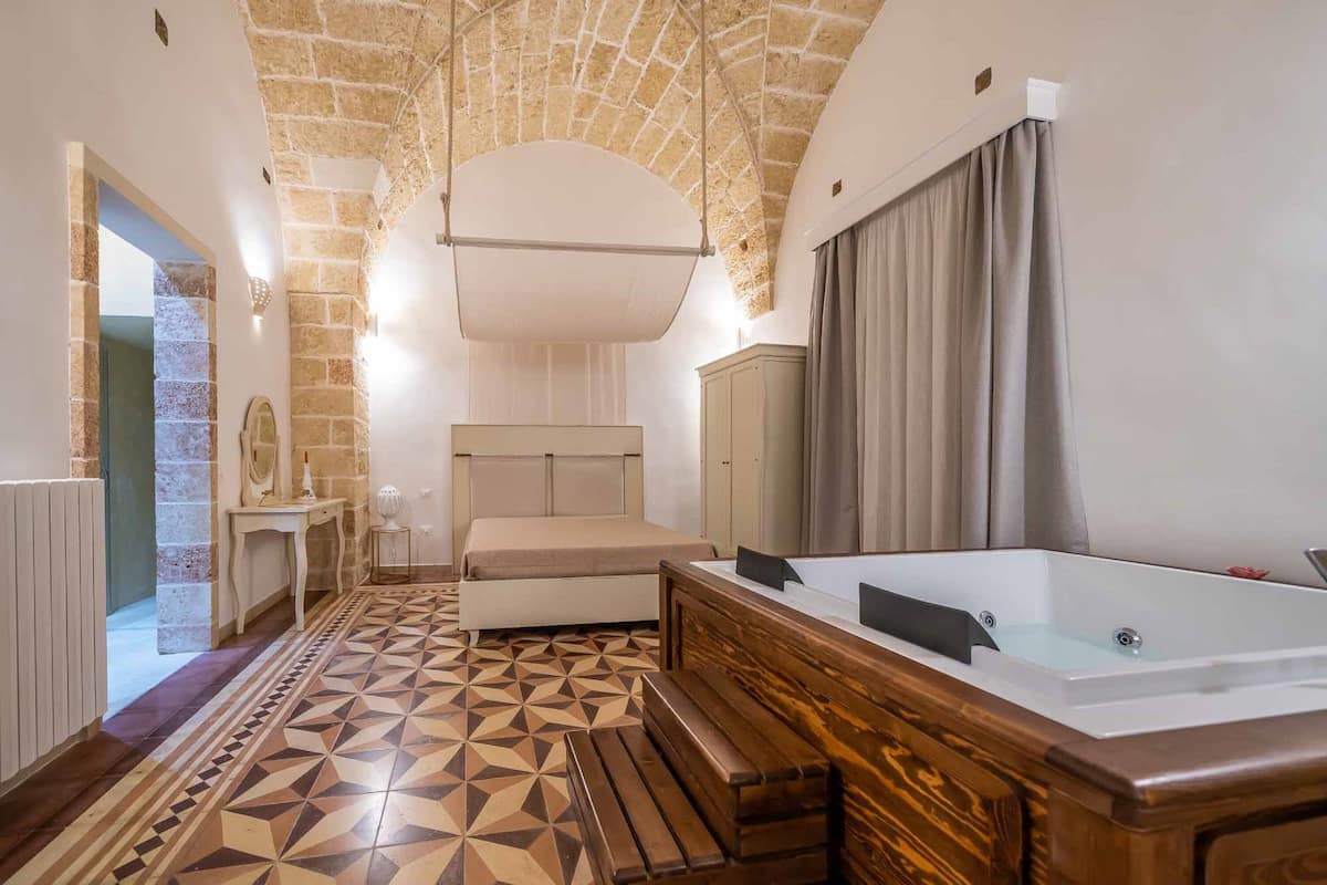 Ein modernes Badezimmer mit einer freistehenden Badewanne, einer Holzbank und einem gemusterten Boden.