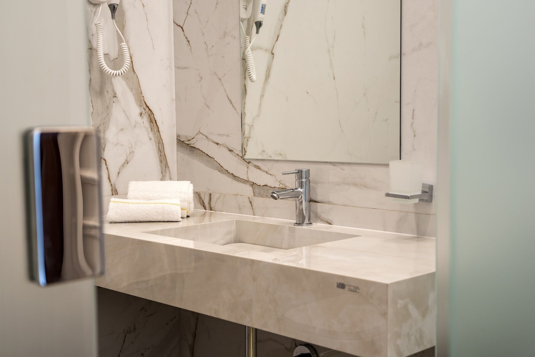 A bathroom with two sinks, a mirror, and a towel rack.