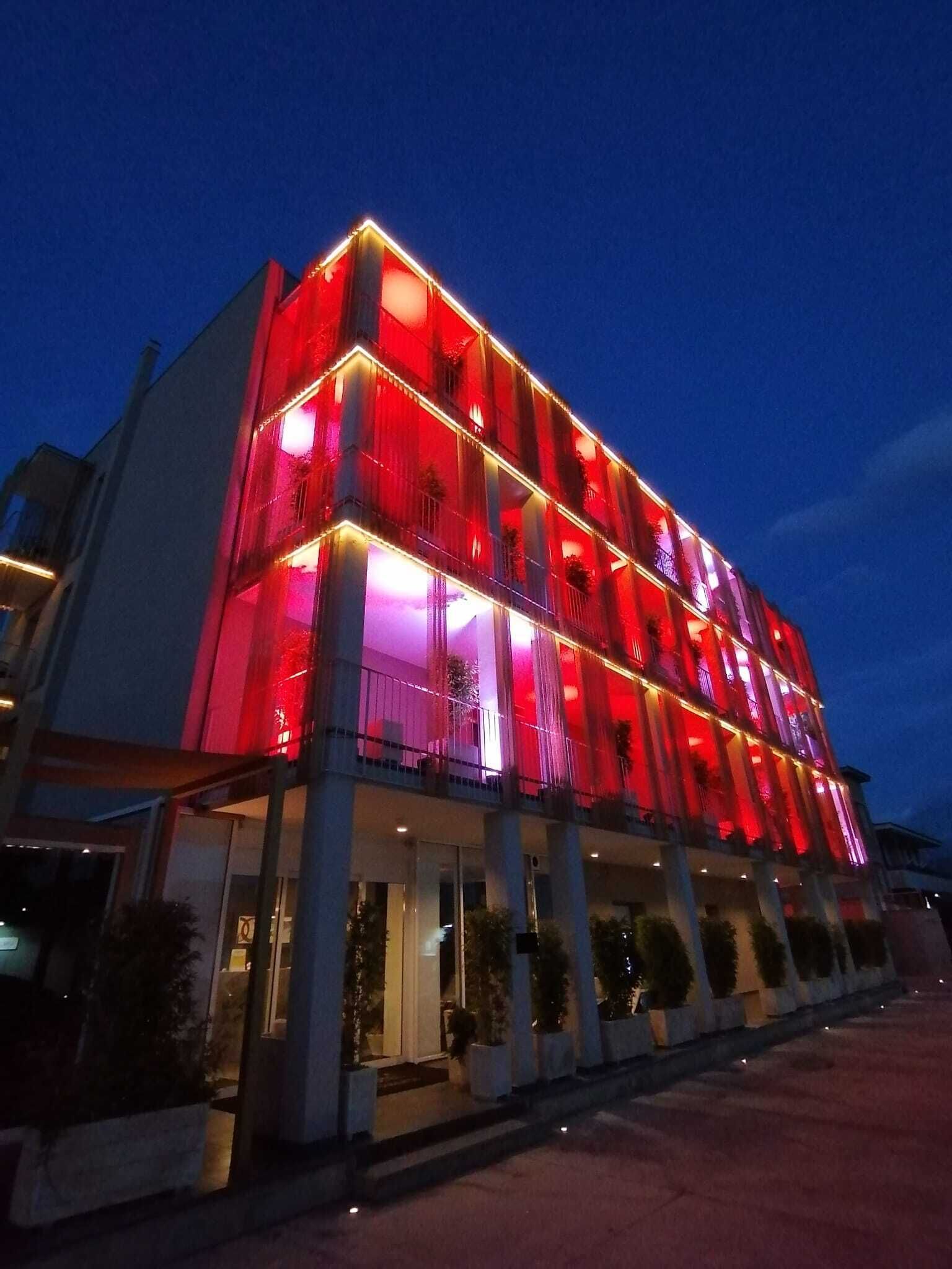 Ett hotell med flera våningar, balkonger och en väl upplyst fasad.
