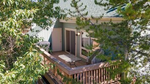 A wooden deck with a table and chairs, surrounded by trees. - Twin Rivers Vasquez 3 Perfect 3 Bedroom sleeps 9, private deck, river views (Fraser)