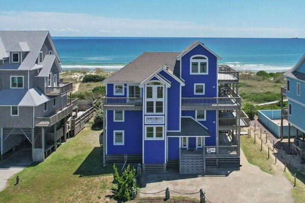 A multi-story house with a balcony, located near the beach with a view of the ocean. - Oceanfront Home with Private Pool, Hot Tub, Elevator and Wet Bar (Frisco)