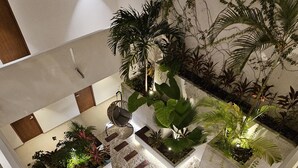 Ein moderner Innenbereich mit einem Garten, verschiedenen Pflanzen und einem zentralen Wasserspiel.