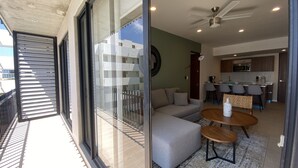 Ein modernes Wohnzimmer mit Sofa, Couchtisch und Blick auf den Balkon.