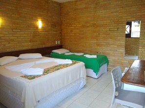 A hotel room with two beds, a wooden desk, and a mirror on the wall. - Pousada Porto do Colibri (Ipojuca)