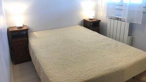 A small, neatly made room with a single bed, two bedside tables, and a radiator. - 1st floor, tv, ski locker, 58m², Villard de Lans (Corrençon-en-Vercors)