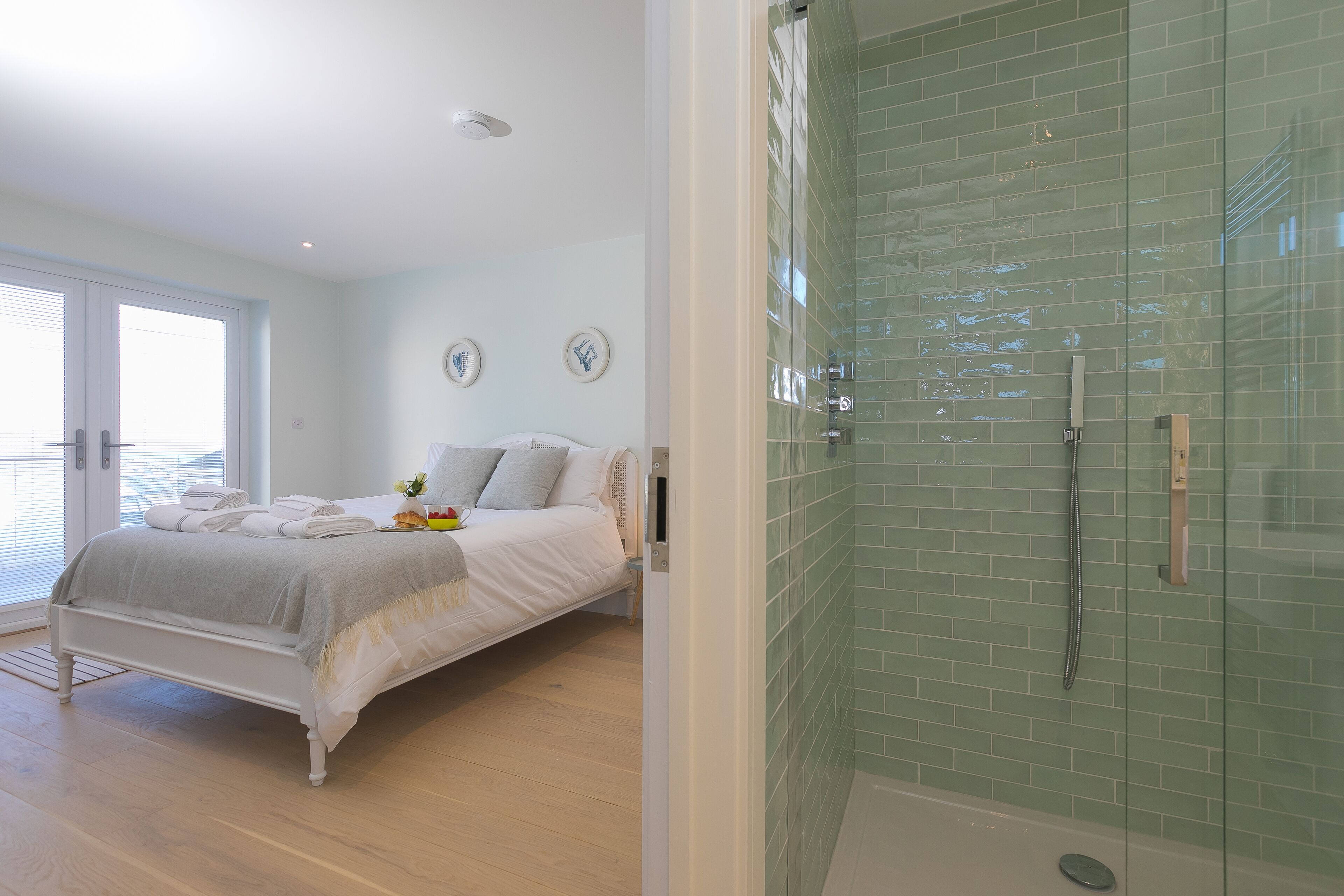 A bedroom with a bed, a bedside table, and a window.