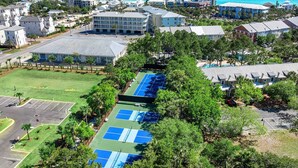 Zona residencial con cancha de tenis, casas y un edificio grande.