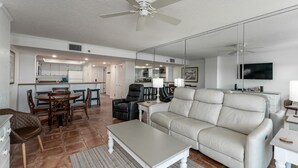 A modern living room with a sofa, coffee table, and dining area.