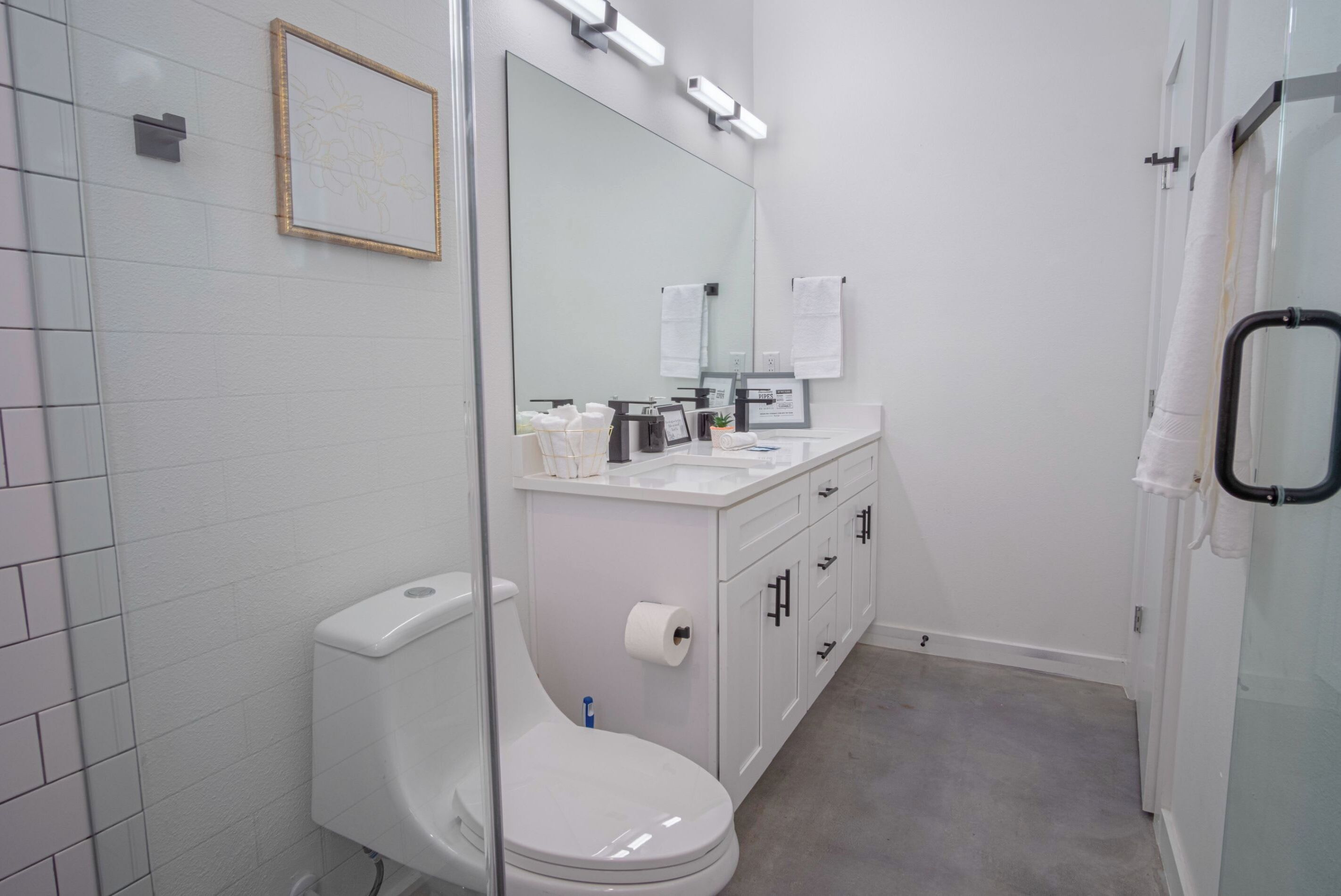 A modern bathroom with a toilet, sink, and shower area.